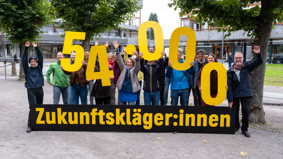 Eine Gruppe von Menschen steht vor dem Bundesverfassungsgericht, vor ihnen ein Banner mit der Aufschrift Zukunftsklägerinnen